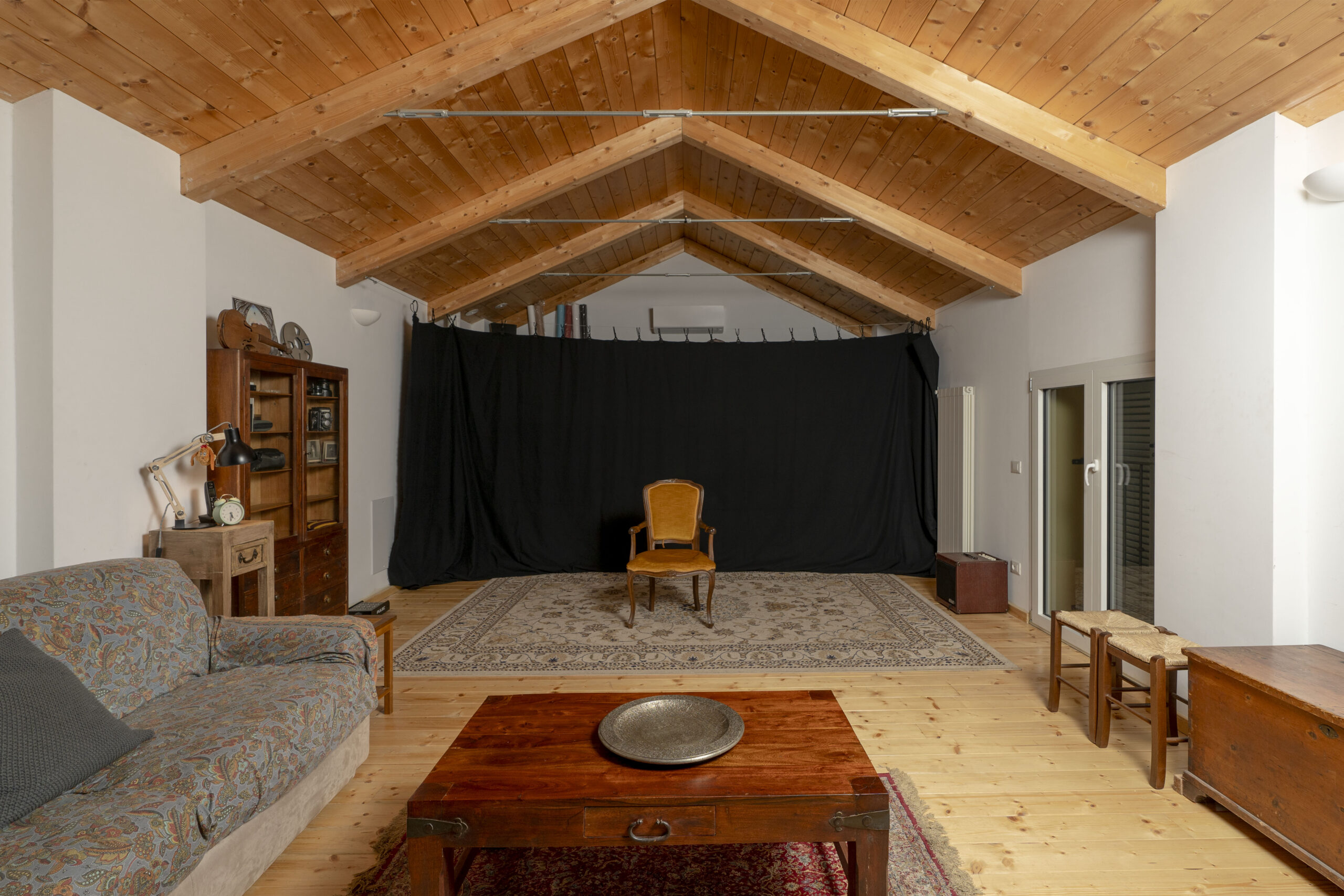 La sala con il soffitto in legno, con divano e tappeti